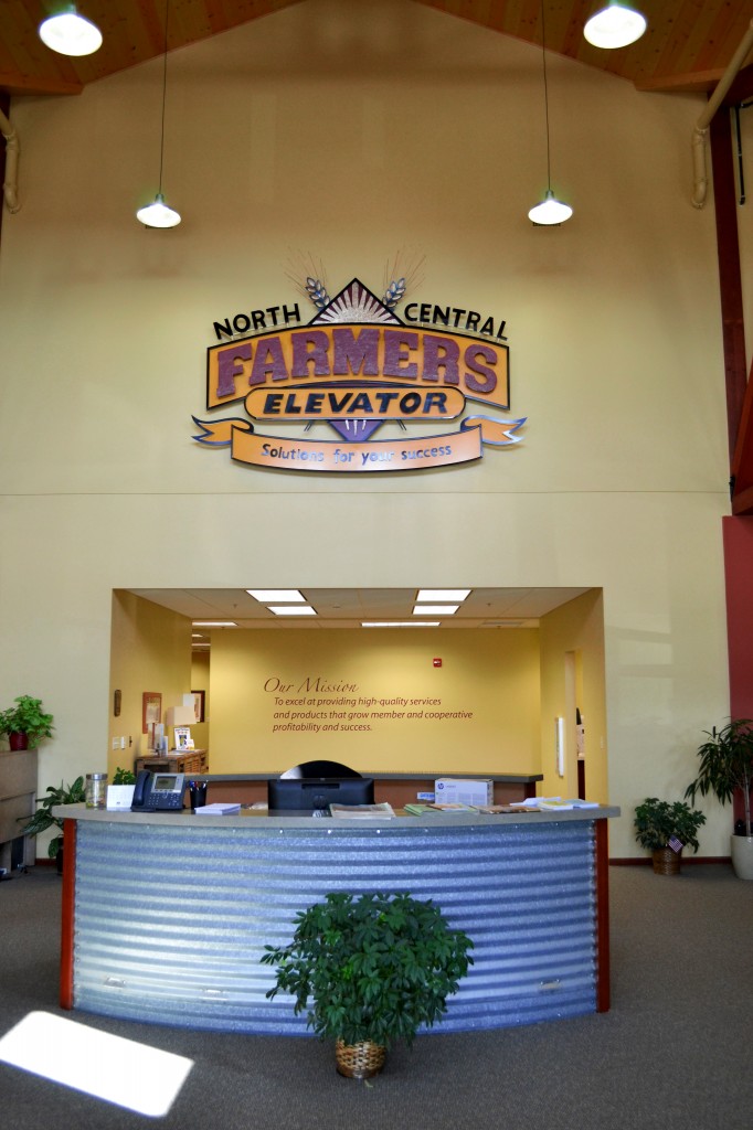 The reception desk sits below a custom, hand-made welded steel replica of the NCFE logo, perched prominently above the company’s mission statement, “To excel at providing high-quality services and products that grow member and cooperative profitability and success.” The reception desk itself features a panel of curved, rippled steel, resembling the exterior of a grain bin. More steel panels, taken from an old wood house elevator at the Craven terminal, were installed on the ceiling of the board room. Photo courtesy NCFE