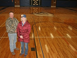Doland school board members Dwight Lyren and Julie Schneider stand on the new gymnasium floor that was replaced with money raised in just a few days when the community was made aware of the need.