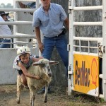 Carter Schulte shows professional skills at mutton bustin’ as Saddle Club President Chad Homan keeps a vigilant eye on the proceedings on July 2 in Faulkton. Photo by Faulk County Record