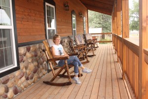 Sherie Tellinghuisen sits in one of the rockers on the porch of the Home Town Hotel in Willow Lake. Photo by Clark County Courier