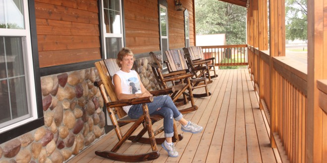 Sherie Tellinghuisen sits in one of the rockers on the porch of the Home Town Hotel in Willow Lake. Photo by Clark County Courier