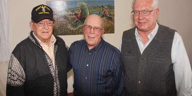 Carroll Peterson, left, of Webster, and John Audus, middle, of Clark, were in the same company in World War II, unbeknownst to each other. Marlin Fjelland, right, of Clark, found out about them both being on the same plane for a short while on Christmas Day 1944. Fjelland helped the two get acquainted and reminisce about this fateful trip home. Photo by Clark County Courier