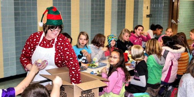 Britton-Hecla Food Service Manager Rosie Cease hands out dessert to Britton-Hecla students the day before Christmas vacation. Photo by Britton Journal