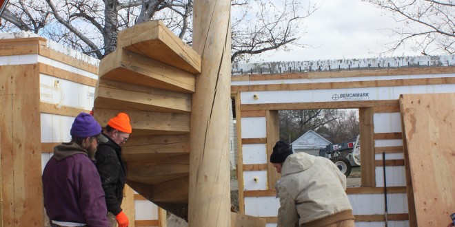 A home being constructed by Ross Hansen (left rear) and Pfeifer & Son Construction in Faulkton will feature a number of unconventional designs and materials, such as this spiral staircase.  	“The tree it’s cut from was a spruce that was 70 feet tall and was downed in 2007 by fire kill,” Hansen said in October 2012, when they were working on this staircase. “I milled it in 2008. It was about 80 years old… The center pole has a metal core base that goes into the floor, and each of the stairs was cut to be driven into the wood and held by epoxy.” Photo by Garrick Moritz/Faulk County Record