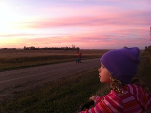Erik Losure, 5, and Sofia Losure, 7, stop during a bike ride to enjoy the colors of a beautiful Dakota sunset. In less than 10 years, a transmission line is slated to be built in that sunset view. Photo by Heidi Marttila-Losure