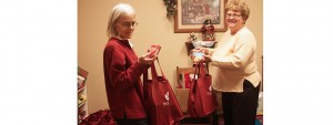 Frances Heeren, employee of the Interlakes Community Action Program thrift store, and Jeanie Fuller, ICAP county director, fill Christmas bags to be distributed this week. Photo by Bill Krikac, Clark County Courier