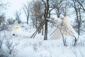 Three tipis sit camouflaged by trees and snow at the Lakota winter camp held by the Cloud Horse Art Institute on Pine Ridge Reservation. These camps, led by Tilda Long Soldier St. Pierre and her husband, Mark, offered native youth a firsthand understanding of their ancestors’ experience of winter life, including astronomy, biology, cooking, games and storytelling. The camp was most recently held in 2010. Photo by Mark St. Pierre
